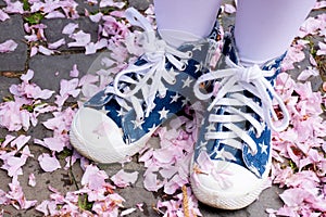 legs in blue starlet sneakers on fallen sakura