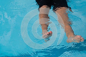 Legs of a boy drowning in the pool.