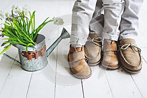 Legs of boy and man, in moccasins with flowers photo