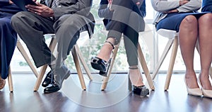 Legs, business people and group in a row in office for a job interview, hiring or recruitment. Chair, feet and corporate