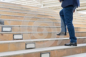 legs of businessman walking stepping up stair in modern city, bu