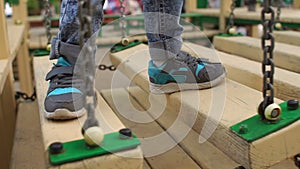 Legs of the child on a wooden bridge. Playground.