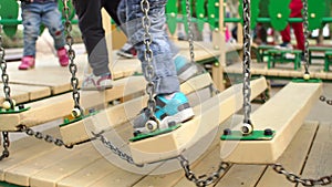 Legs of the child on a wooden bridge. Playground.