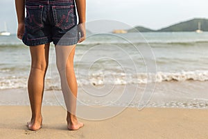 Legs of children stand on the beach