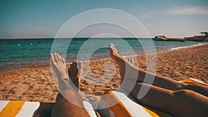 Legs of Couple People Lying on Beach Sun Lounger near the Red Sea