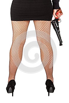 Legs of dangerous woman with handgun and black shoes