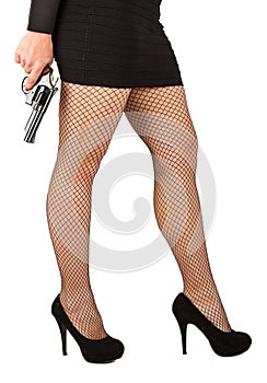 Legs of dangerous woman with handgun and black shoes