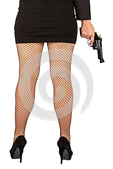 Legs of dangerous woman with handgun and black shoes