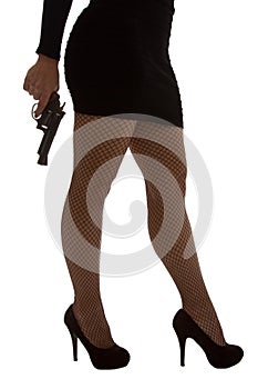 Legs of dangerous woman with handgun and black shoes