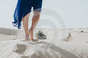 Legs in desert with blue dress