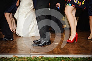 Legs down image of people dancing at wedding reception.