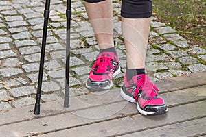 Legs of elderly senior woman and nordic walking sticks, sporty lifestyles