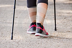 Legs of elderly senior woman practicing nordic walking, concept of sporty lifestyles in old age