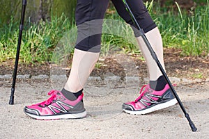 Legs of elderly senior woman practicing nordic walking, concept of sporty lifestyles in old age