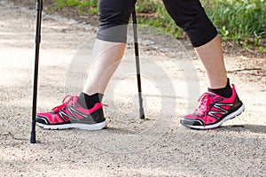 Legs of elderly senior woman practicing nordic walking, sporty lifestyles in old age