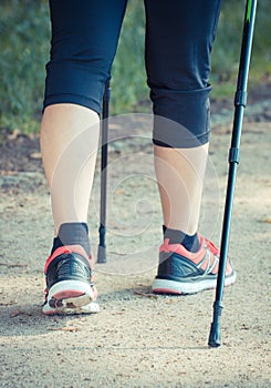 Legs of elderly senior woman practicing nordic walking, sporty lifestyles in old age concept