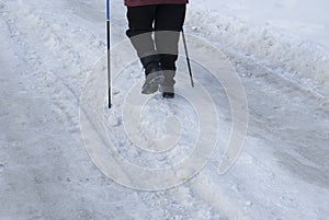 Legs of an elderly woman engaged in Scandinavian walking