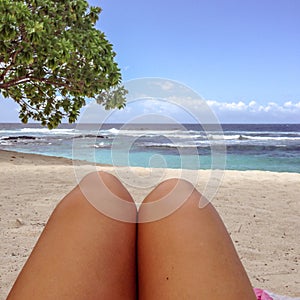 Legs with fake spray tan on sun lounger on tropical beach at Lefaga, Upolu Island, Samoa, South Pacific photo