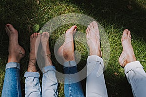 Family with bare feet resting on the grass