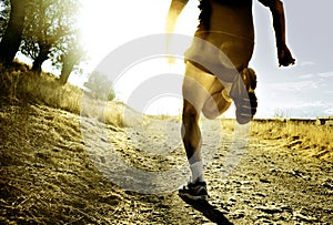 Nohy a extrémní kříž země muž běh trénink na venkov západ slunce 