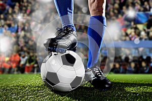 Nohy a z fotbal hráč v modrý ponožky a černý obuv stojící koule zápas na stadion 