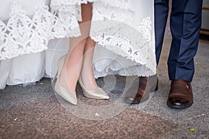 Legs and feet of married couple in stylish shoes