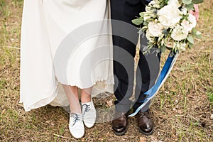 Legs and feet of married couple in stylish shoes