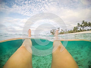 Legs and feet POV - split point of view of woman floating in clear sea at a beach at Matautu, Lefaga, Upolu Island, Samoa, South photo