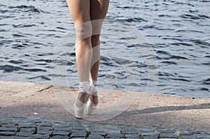 Legs of a female ballet dancer practising on the street with pointe shoes