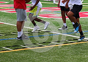 Legs of football players running through ladder drills at summer camp