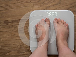 Legs of a full girl on electronic scales