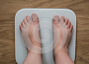 Legs of a full girl on electronic scales