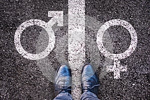 Legs with gender symbol on asphalt