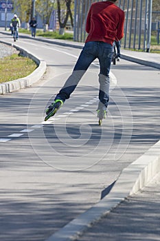 Legs of girl having roller skate exercise along roadline