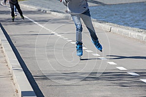 Legs of girl having roller skate exercise along roadline