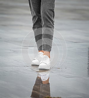 Legs of a girl in rainy weather on the street in the city