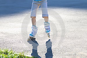 Legs of girl roller skating on playground