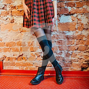 legs of a girl in skirt and black boots