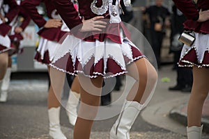legs of girls with sexy costume of cheerleader parading in the street
