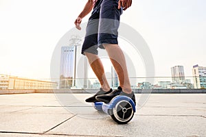 Legs of guy riding gyroscooter.