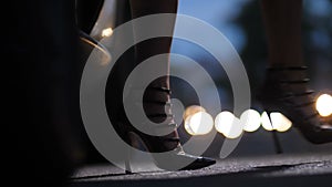 Legs in high heels stepping out of car at night