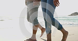 Legs, holding hands and couple walking on beach, relax or bonding on summer island holiday together. Romance, man and