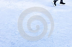 Legs of an ice skater in old vintage skates. Ice skratched background