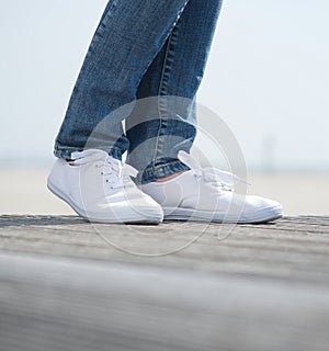 Legs in jeans and comfortable white shoes