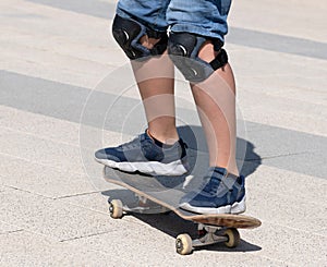 legs in knee pads of teenager on a skateboard