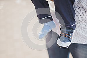 Legs of little boy, one booty is put on his leg