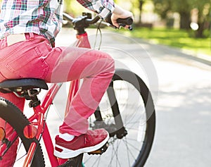 Legs of little girl riding bike in the park