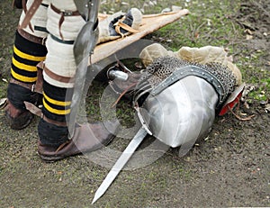 Legs of man and armored metal medieval helmet on
