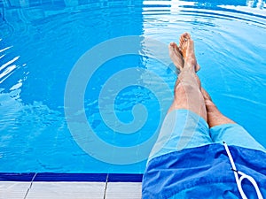 Legs of a man in the pool. Relax concept. Template Copy space for text