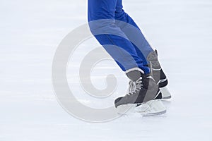 Legs of a man skating on an ice rink. Hobbies and sports. Vacations and winter activities